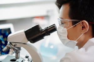 Une nouvelle menace mondiale : l’OMS s’inquiète de la variole du singe plus contagieuse et mortelle Man Looking Through A Microscope