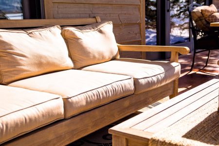 A comfortable outdoor patio seating area with cushions, offering a cozy and modern touch to any home.