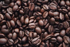 Comment la torréfaction influence le profil aromatique des cafés en grains : une exploration détaillée A detailed view of aromatic roasted Arabica coffee beans, highlighting texture and brown color.